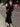 Elegant woman wearing Ellie Skirt Suit with trumpet silhouette, showcasing chic and professional style on city street.