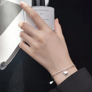 Elegant Silver Heart Bracelet on a woman's wrist, showcasing fine craftsmanship and a charming design.