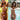 Two models wear Sunbathing Mini Bikini Crochet sets in orange and pink with daisy appliques by the pool.